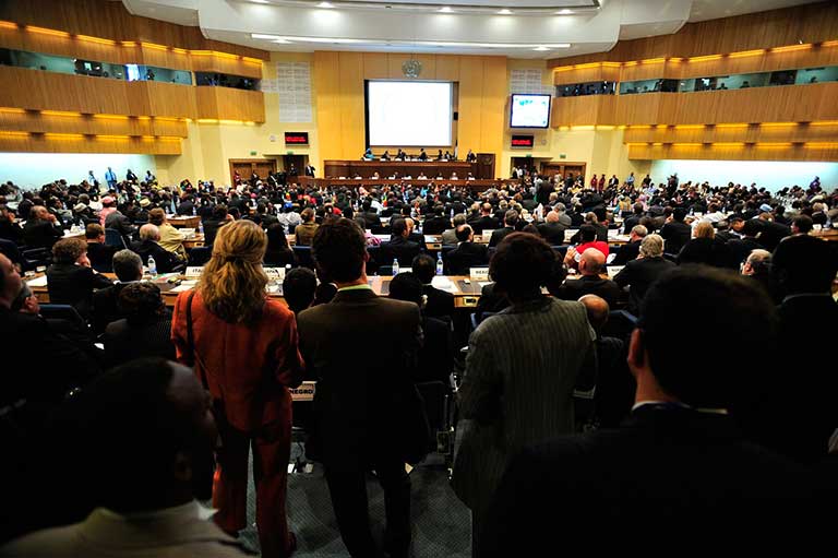 Orador principal en una conferencia emocionante en Málaga, rodeado de asistentes atentos y comprometidos.